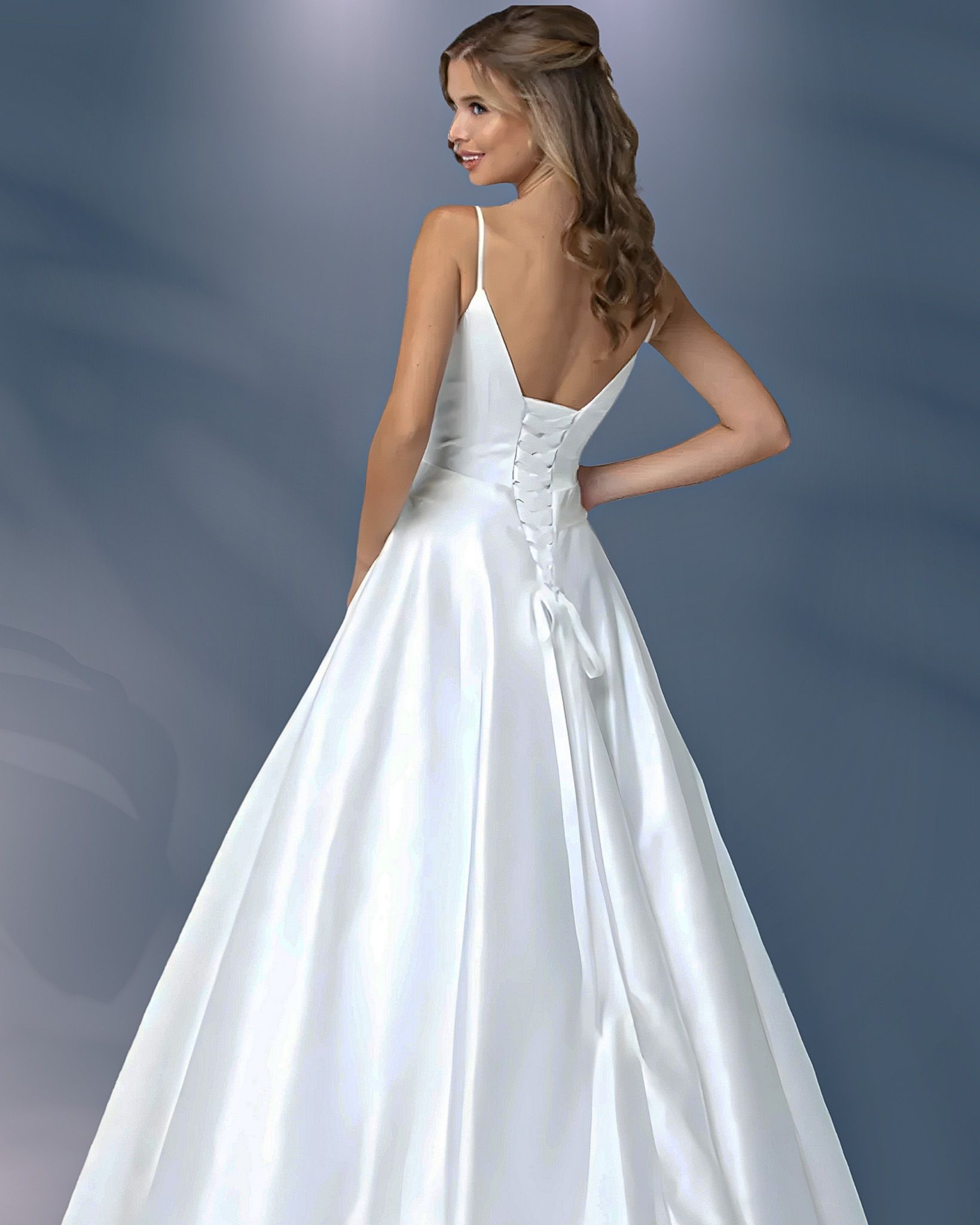 Woman in white wedding dress, turned to the side, with laced back.