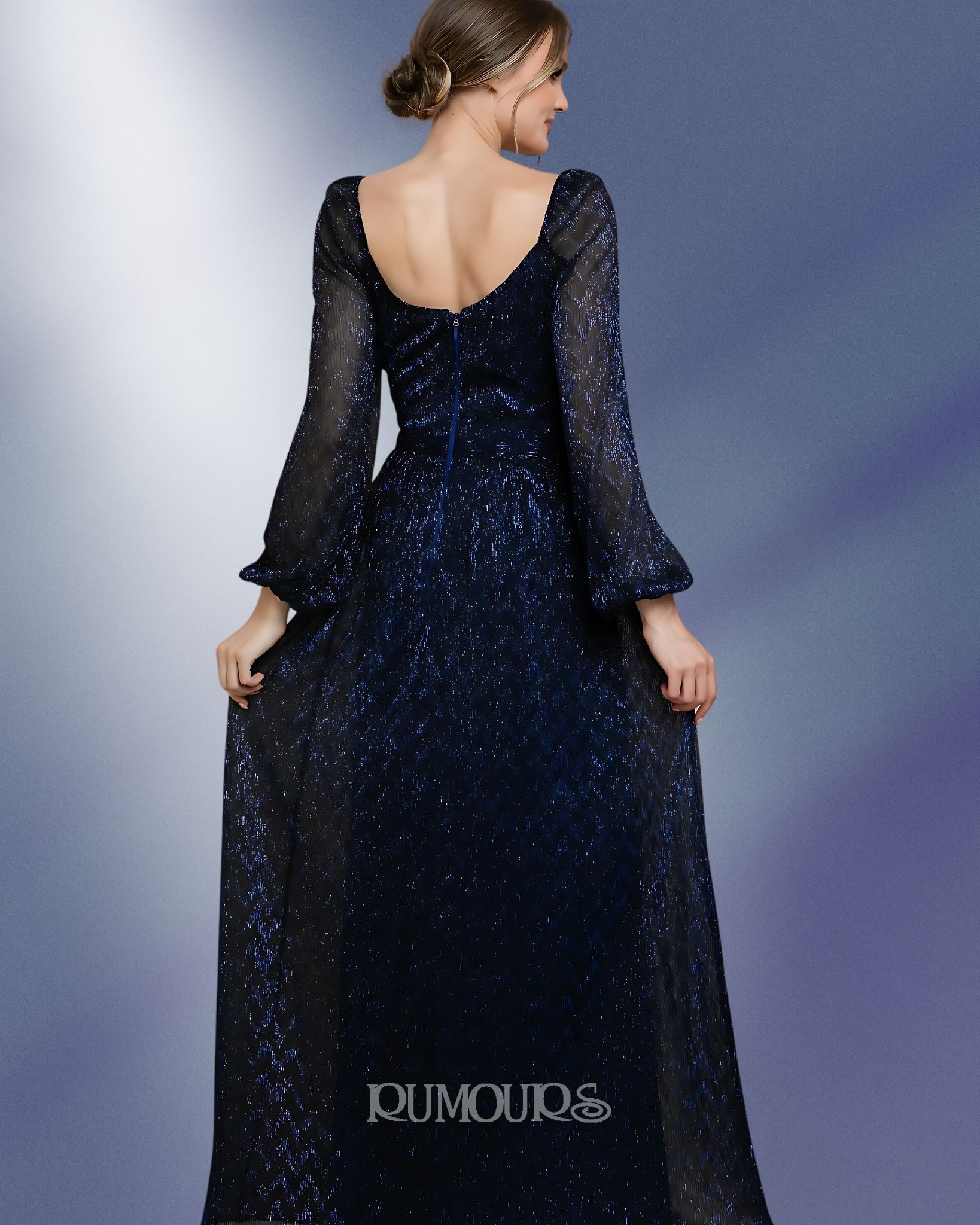 Woman in a dark blue sequined gown with long sleeves and a scoop neckline, standing.