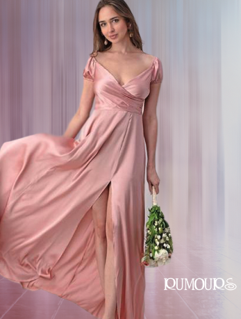 Woman in pink satin gown with a high slit, holding bouquet, standing in front of sheer curtains.