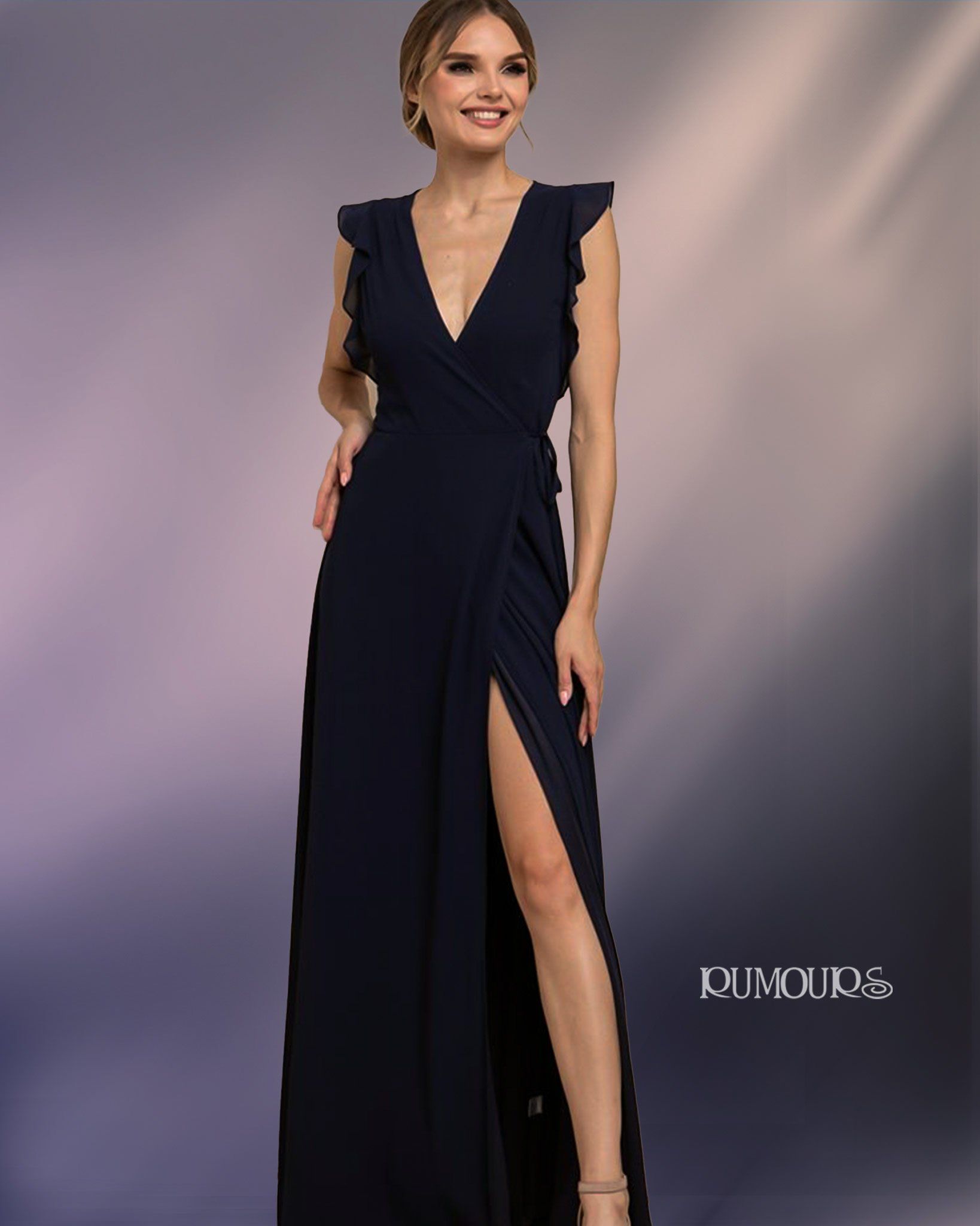 Woman in navy blue formal gown with high slit and ruffled sleeves.