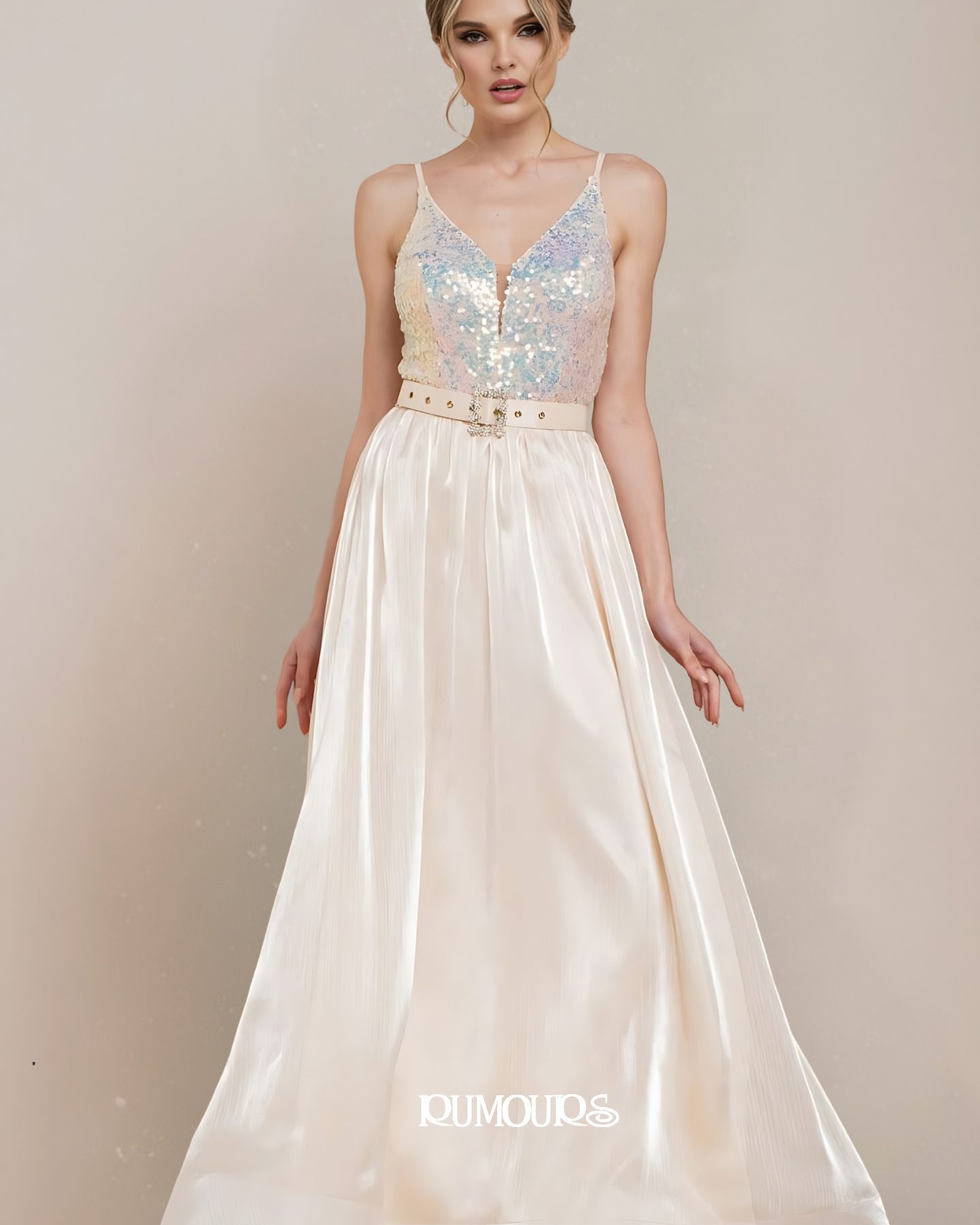 Woman in a long, cream-colored gown with a sequined bodice and belted waist.