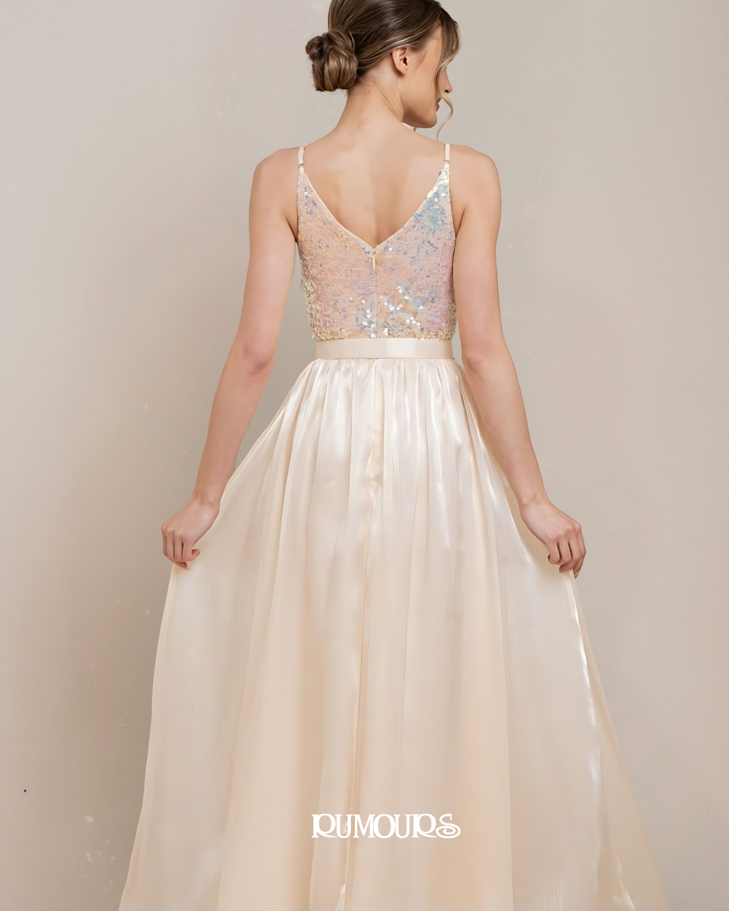 Woman in a formal dress with a sequined top and long, flowing skirt.