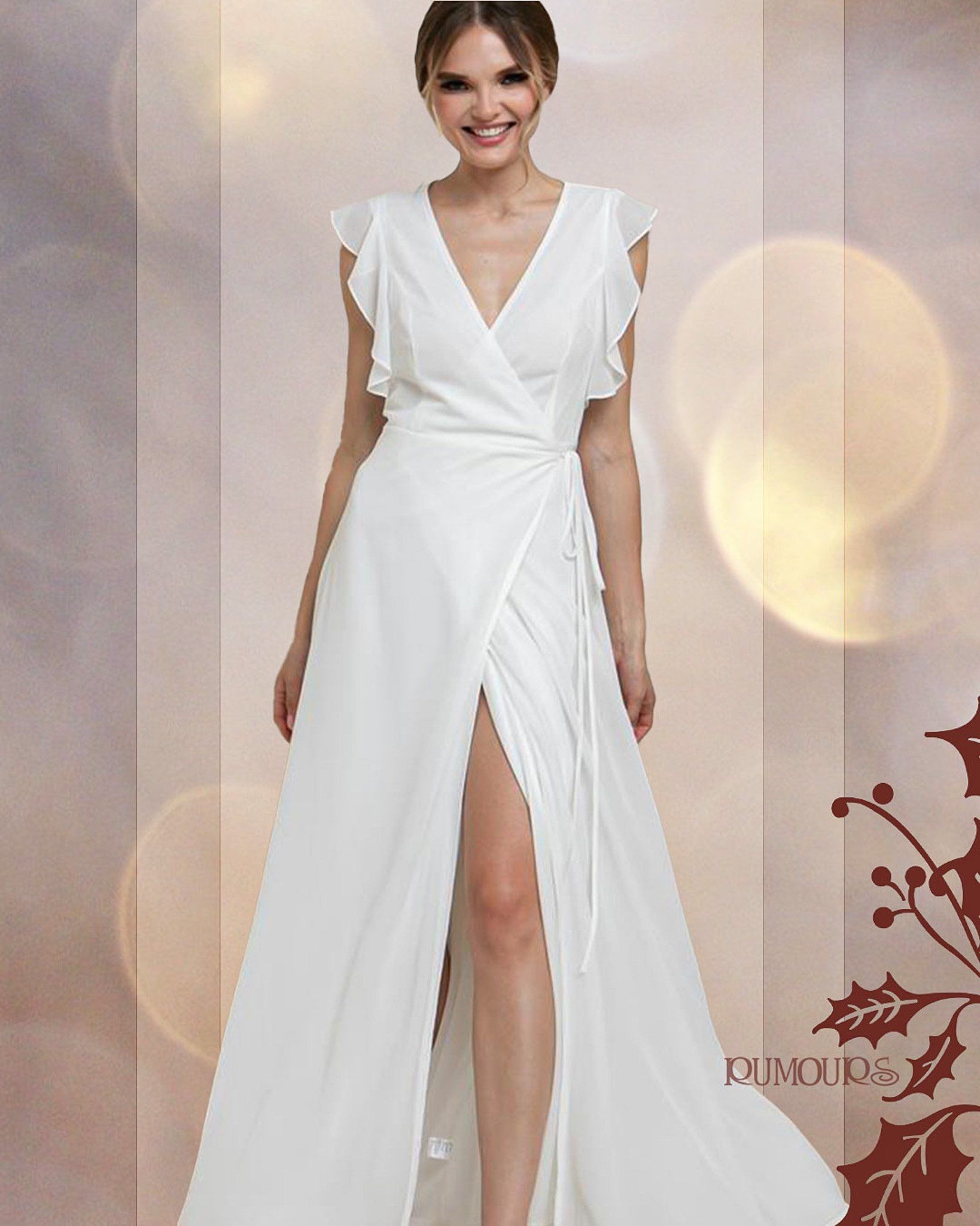 Woman in a white wedding dress with a thigh-high slit, posing with a smile.