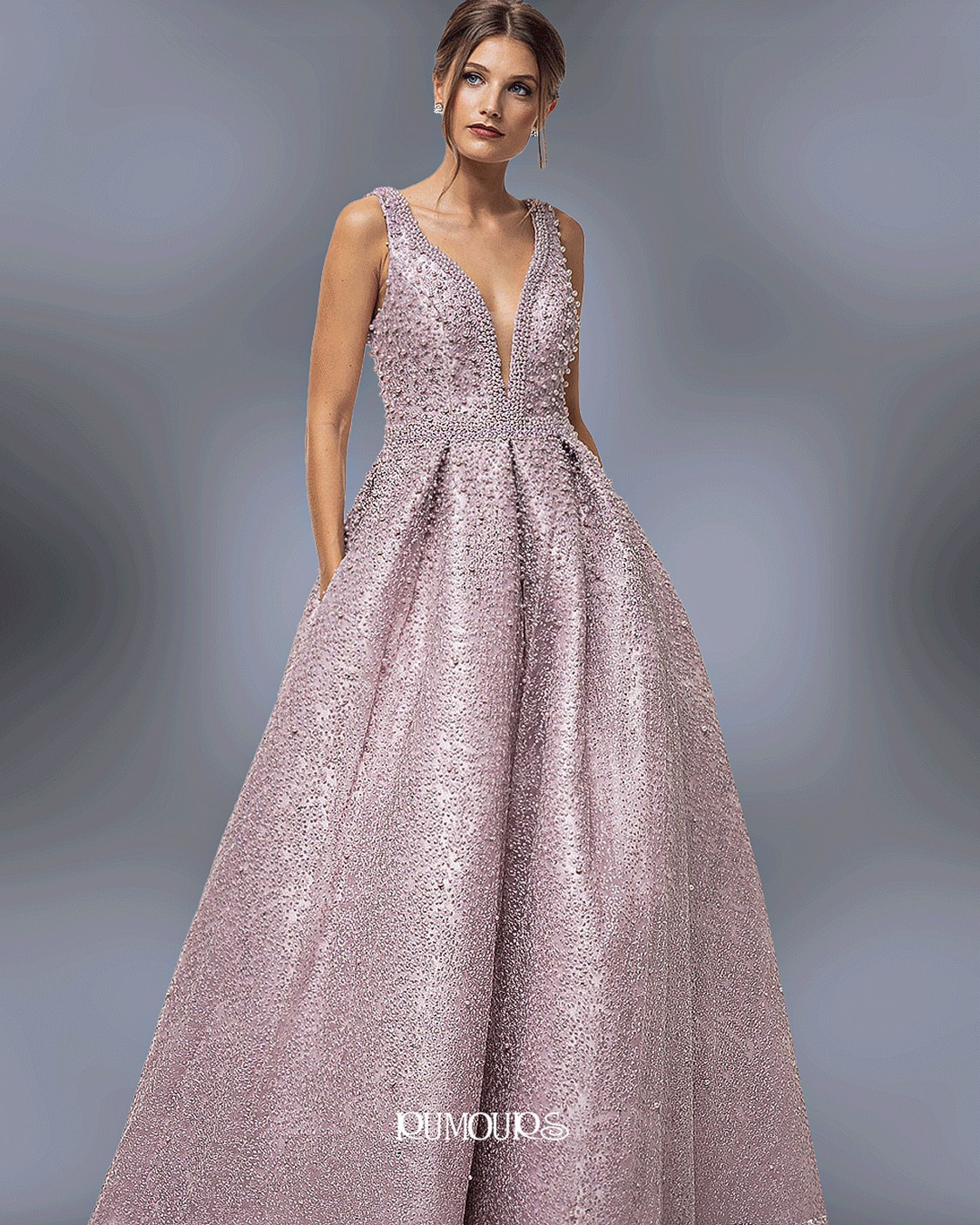Woman in a sparkly pink gown with a plunging neckline and pockets.