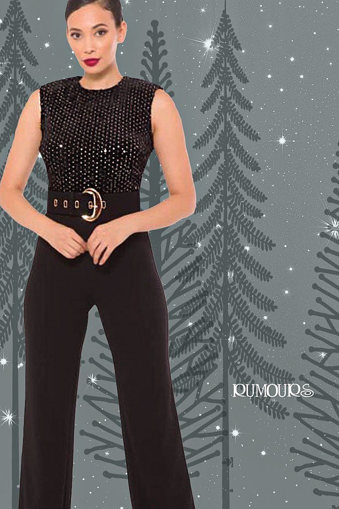 Woman in a black sequined top jumpsuit with belt posing.