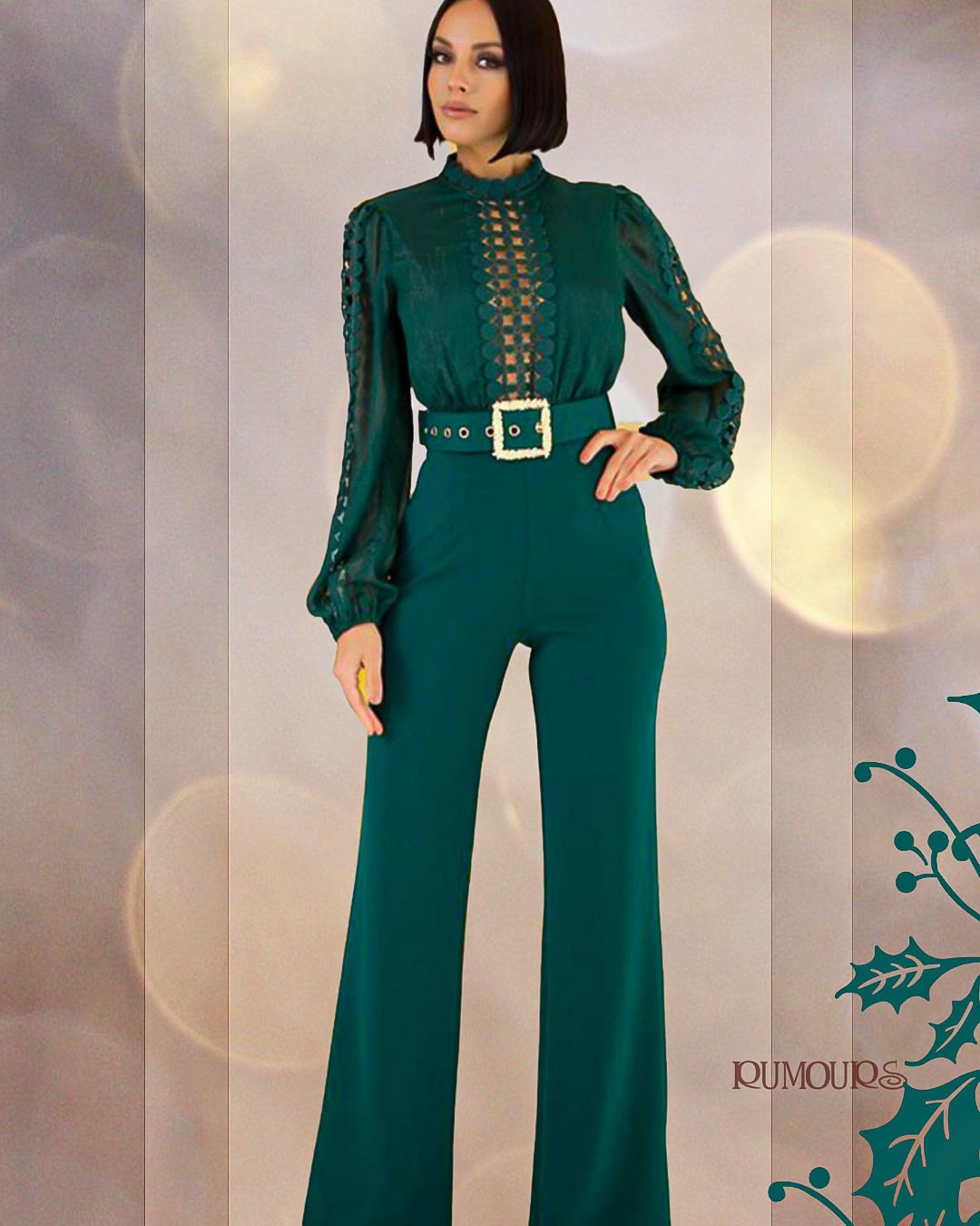 Woman wearing a green jumpsuit with a belt, standing against a blurred background.