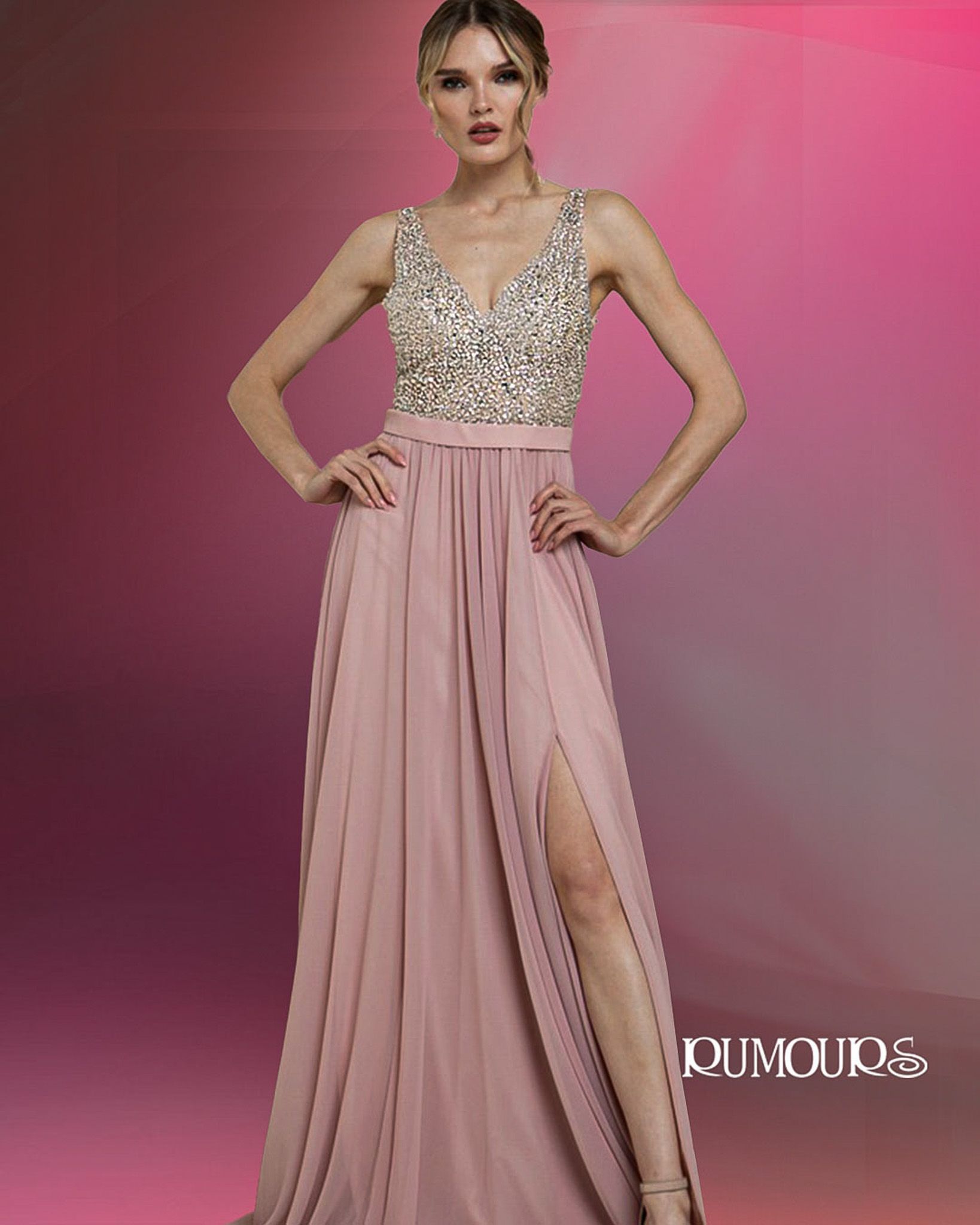 Woman in a pink formal dress with a beaded top, posing with a leg up in front of a pink background.