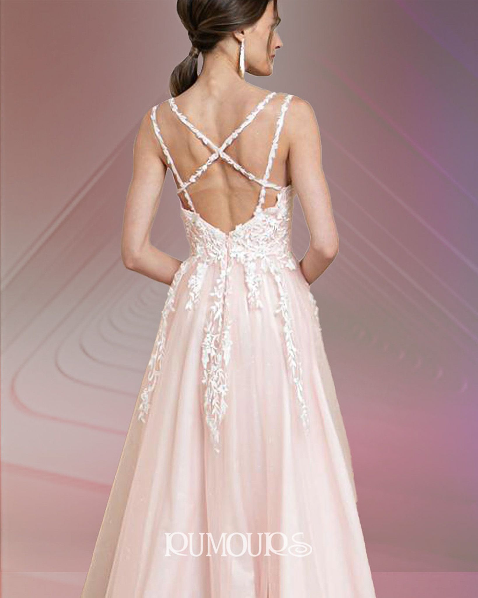 Woman in a pink formal gown with crisscross back detail.