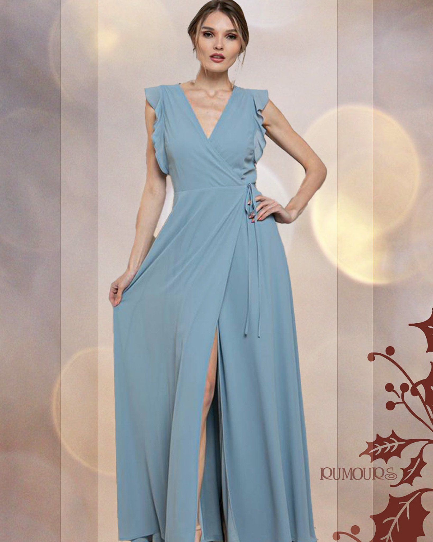 Woman in blue wrap dress with high slit, posing in front of an abstract background.