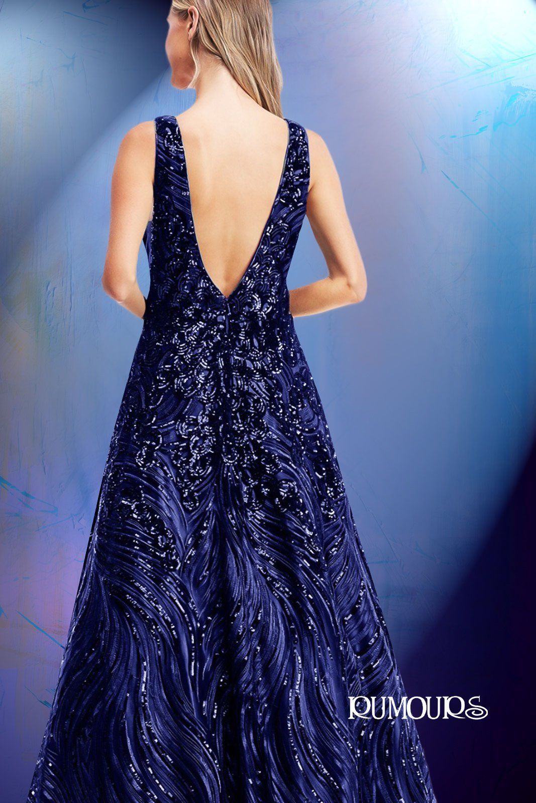 Woman in a navy blue sequined formal gown with a low V-back.