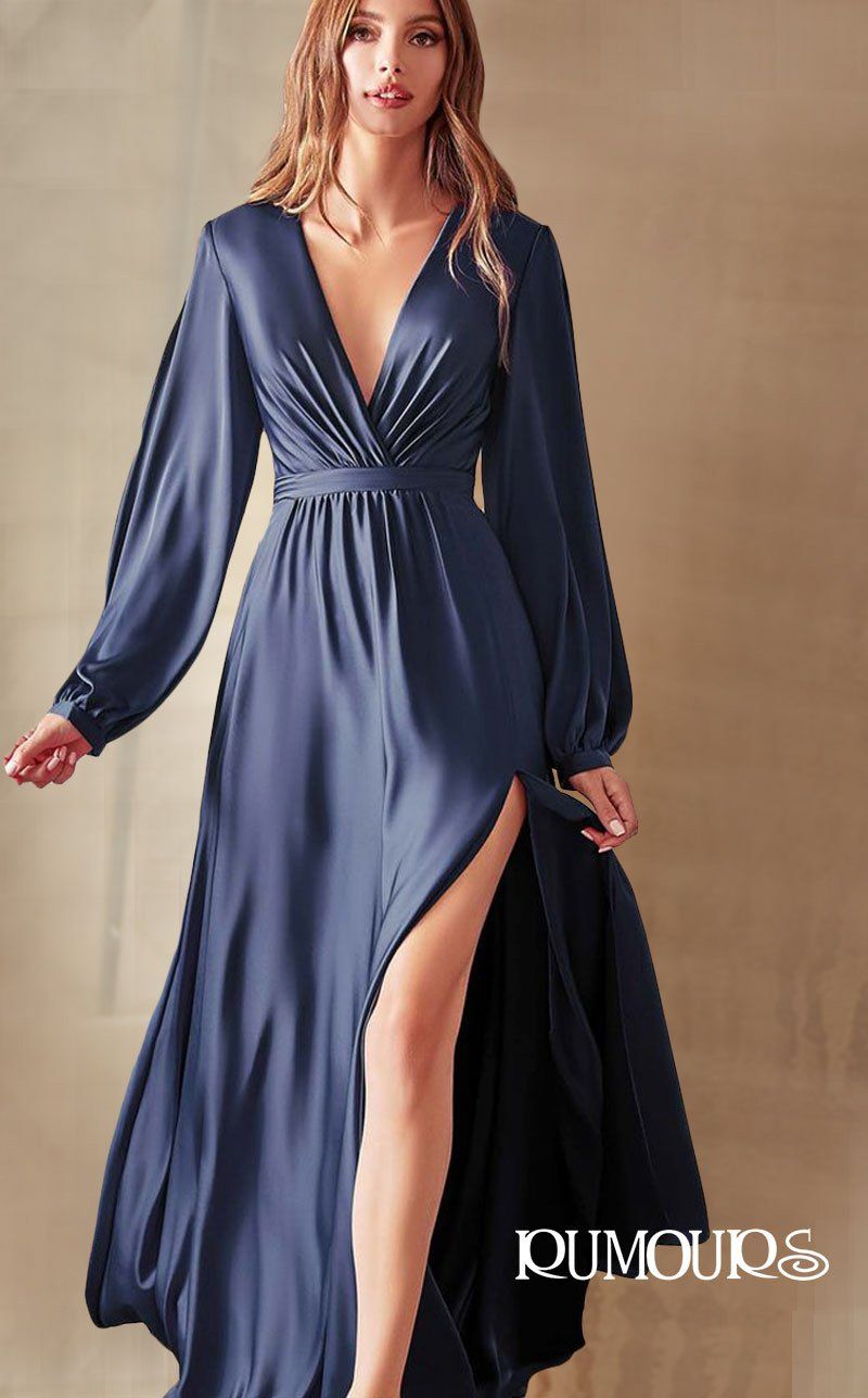 Woman in a navy blue, long-sleeved gown with a thigh-high slit, posing in front of a golden background.