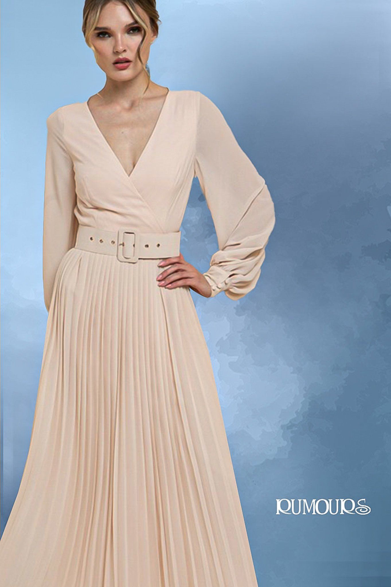 Woman in peach pleated dress with a cinched waist.