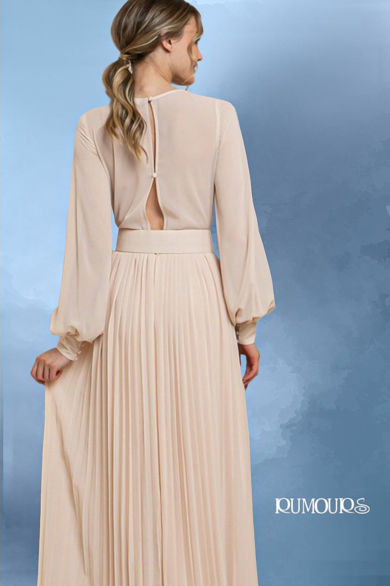 Woman in a beige pleated dress with long sleeves and a keyhole back.