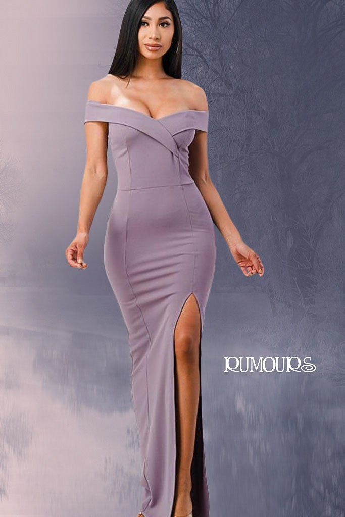 Woman in lilac off-the-shoulder gown with thigh-high slit, posing against a blurred background.