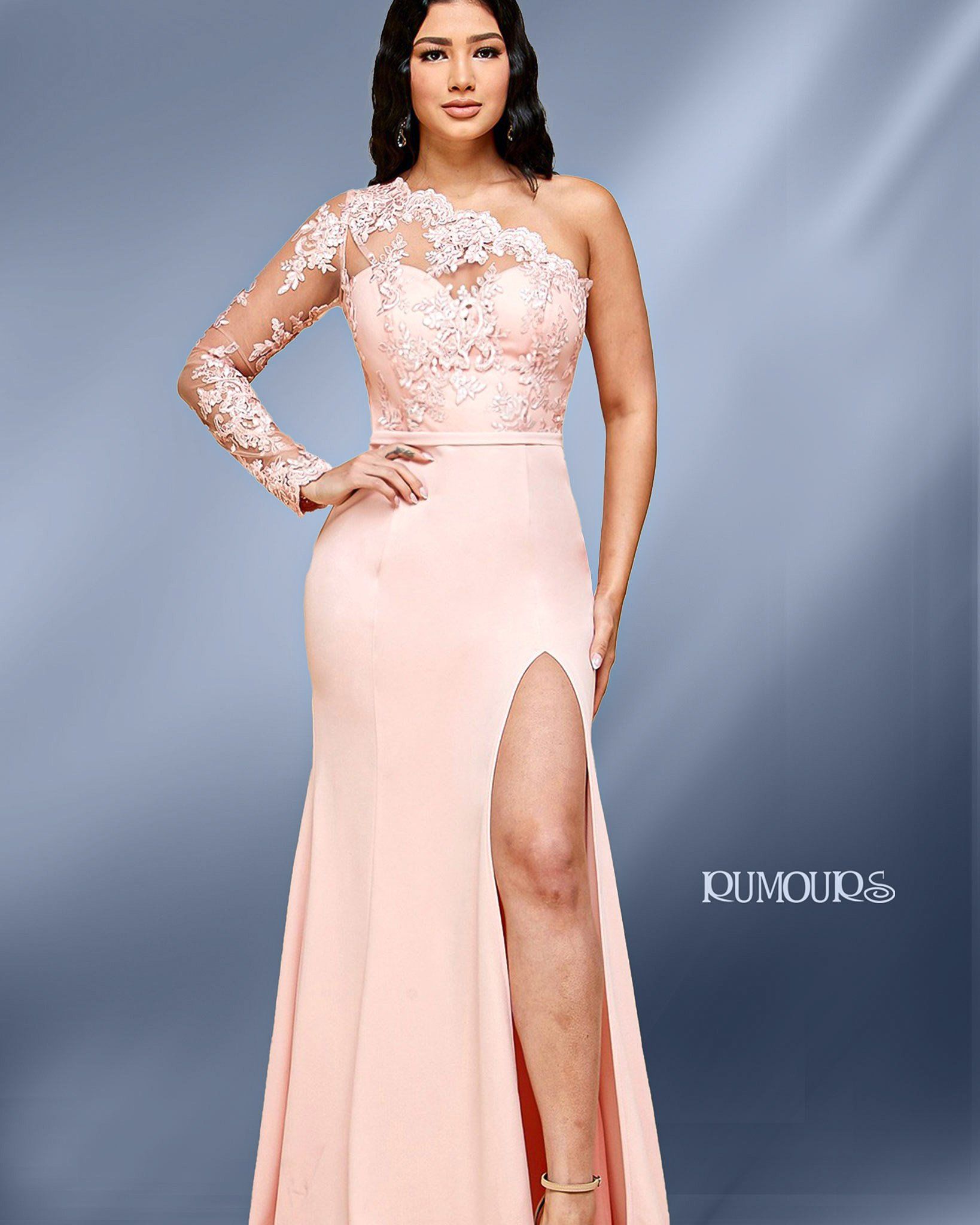Woman in a peach, one-shoulder gown with a thigh-high slit, posing against a blue-gray backdrop.