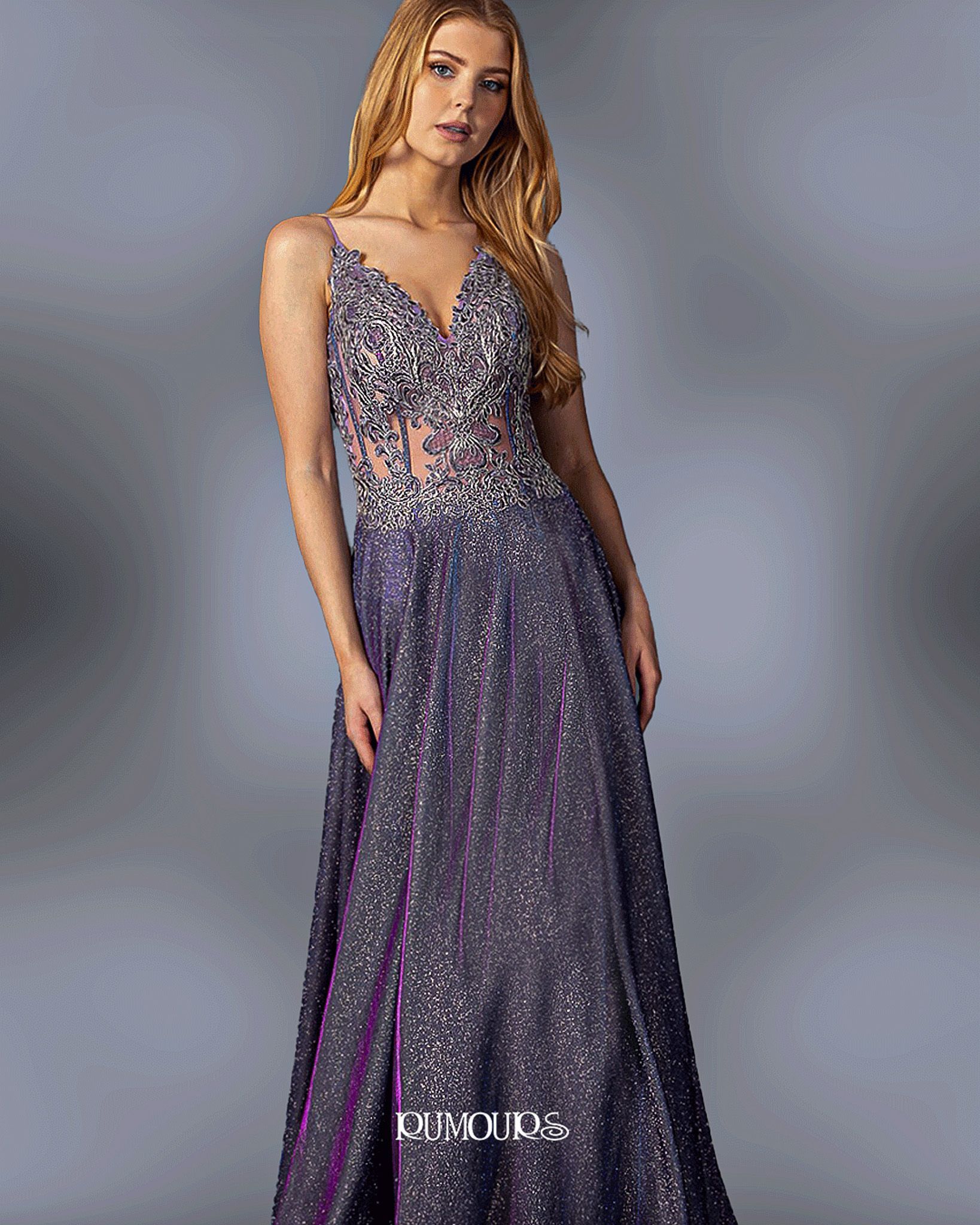Woman in a sparkly purple evening gown with a plunging neckline, posing against a gray backdrop.