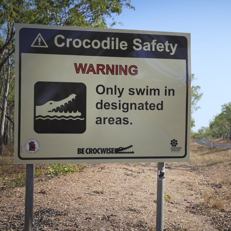 A sign that says crocodile safety warning only swim in designated areas
