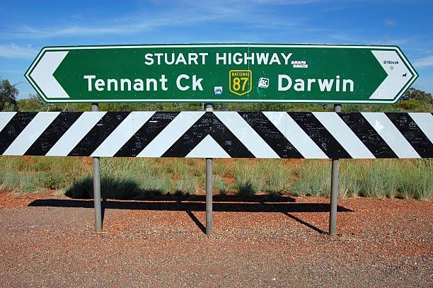 A green sign that says stuart highway on it