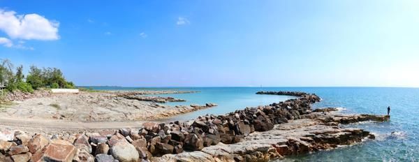 A Man Is Fishing on A Rocky Beach Near the Ocean — Zen Luxury Retreats in Darwin City, NT