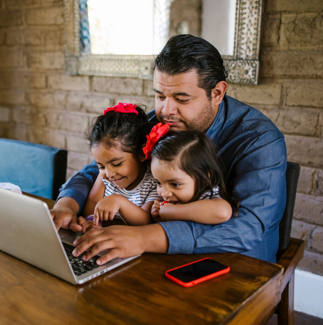 Two people reviewing financial data charts, pointing, with a tablet and coffee cup on a table.