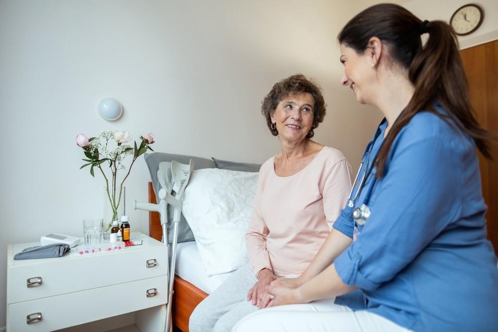 Nurse is Talking to an Elderly Woman in a Hospital Bed — Serenity Strides in Redbank Plains, QLD