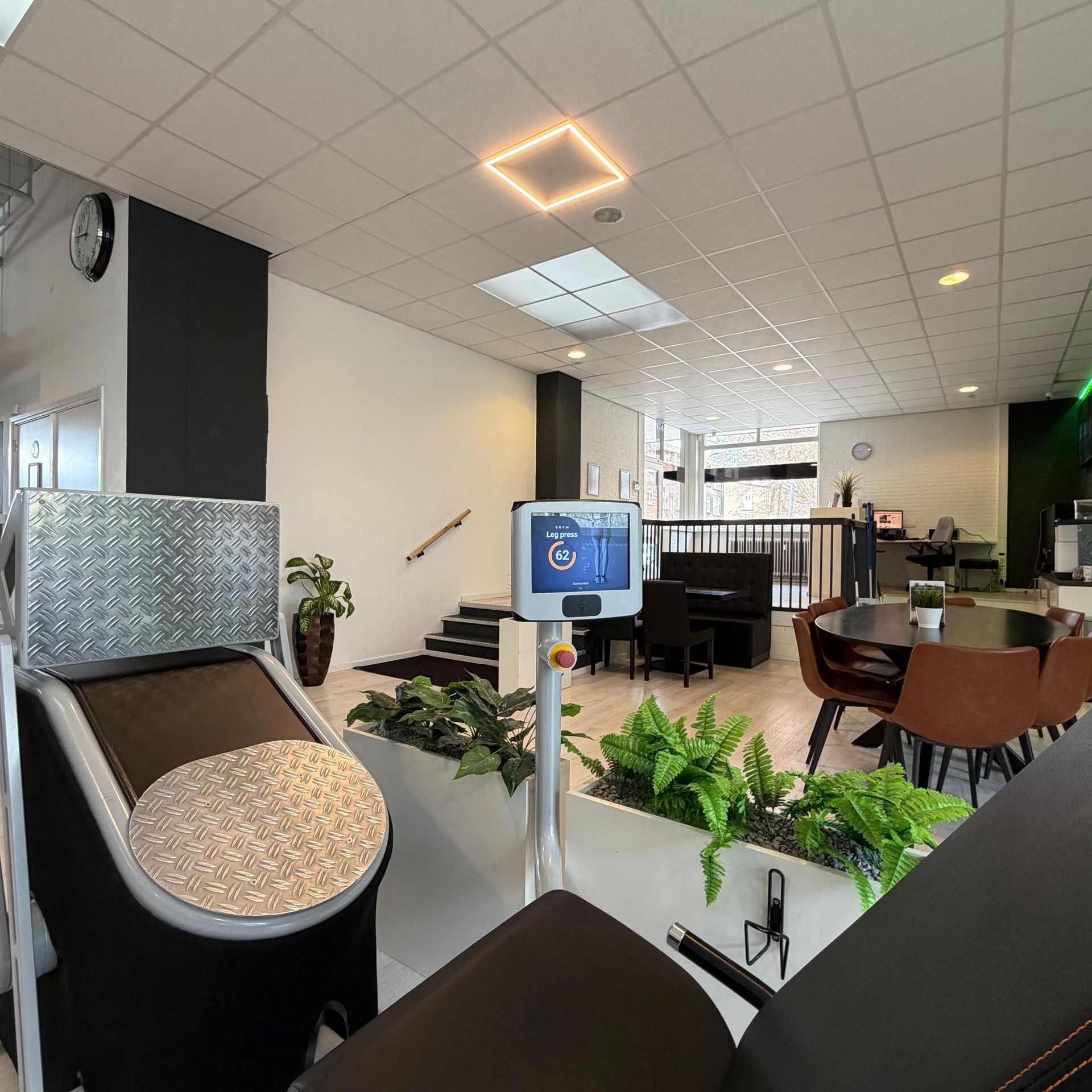 Een sportschool vol met fitnessapparatuur en bloemen.