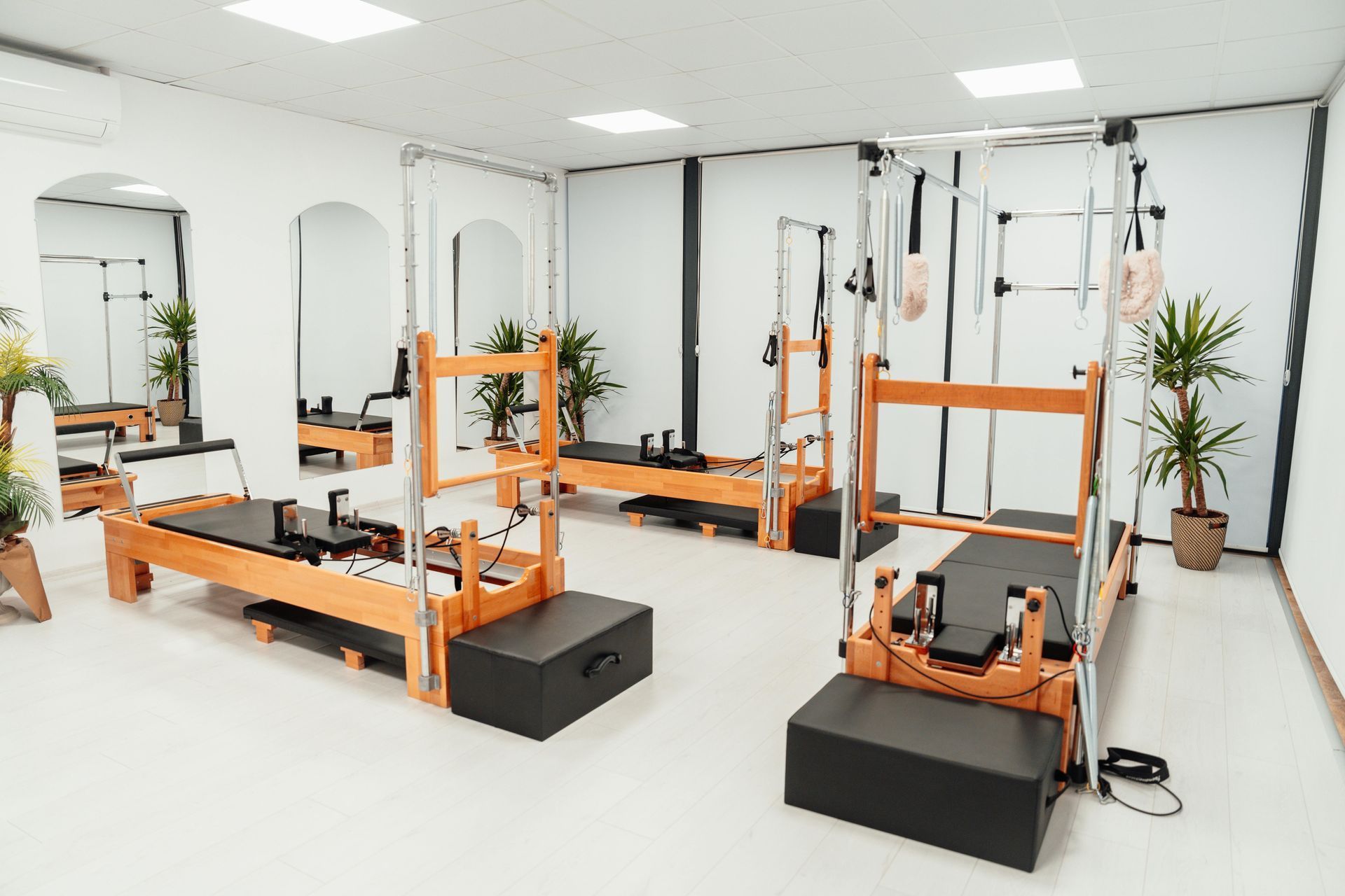 There are a lot of pilates machines in this room.