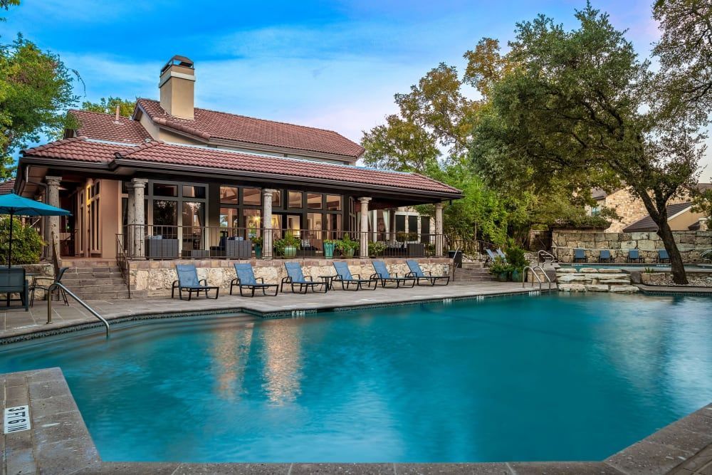 A large swimming pool in front of the clubhouse at Marquis at Caprock Canyon in Austin, TX.
