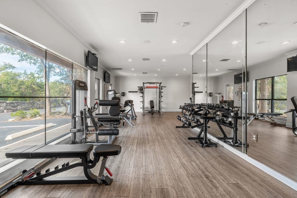 A large gym with a lot of mirrors and exercise equipment at Marquis at Caprock Canyon in Austin, TX.