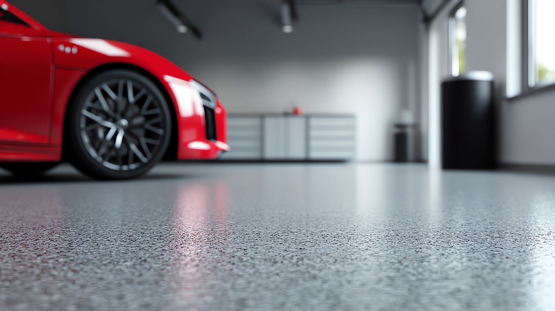 Red sports car parked in a garage with a textured gray epoxy floor.
