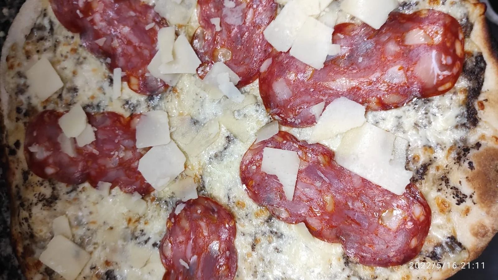Pizza con salame e formaggio, dalla crosta dorata e croccante.