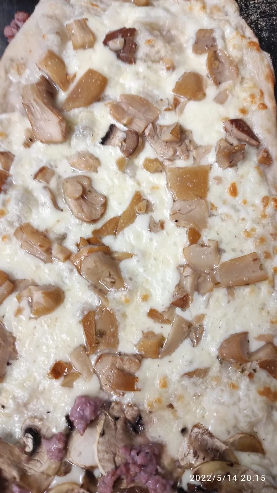 Primo piano di un dessert cremoso guarnito con pezzetti simili al caramello e pezzi di frutta viola.