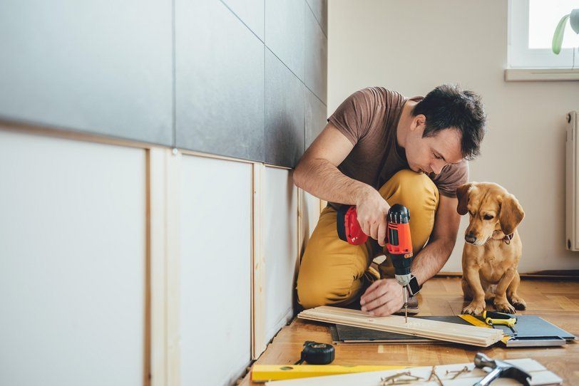 man and his dog drilling a piece of wood