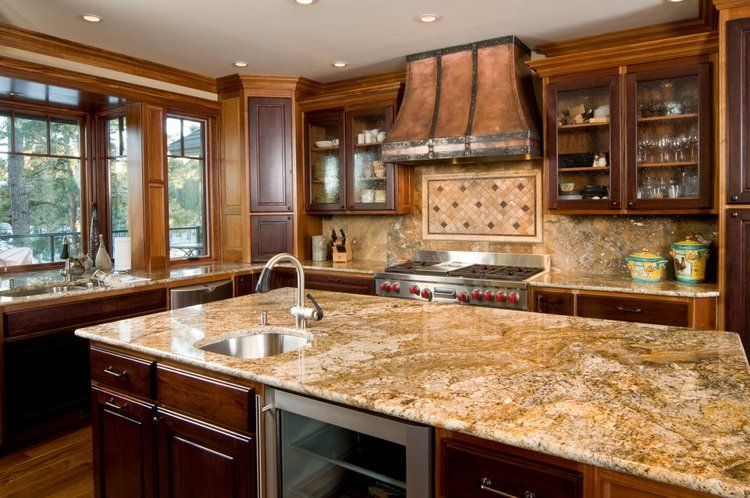 A kitchen with granite counter tops , stainless steel appliances , and wooden cabinets.