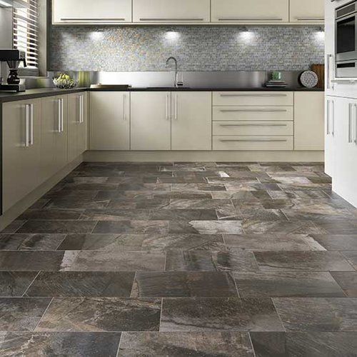 A kitchen with a tiled floor and white cabinets.