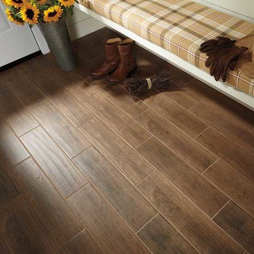 A wooden floor with a bench and boots on it.
