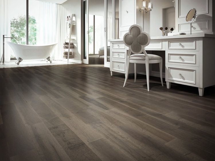 A bathroom with a wooden floor , a vanity , and a tub.