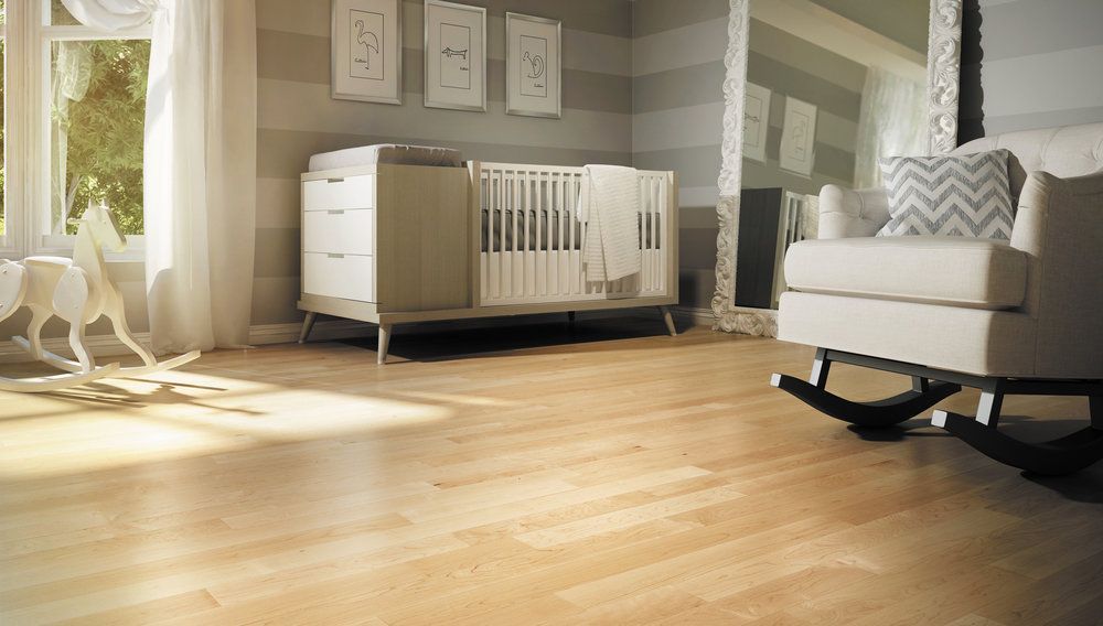 A baby room with a crib , rocking chair , and mirror.