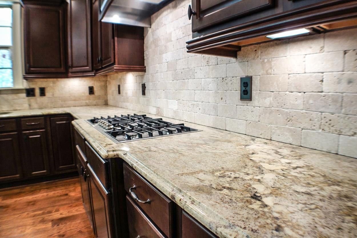 A kitchen with granite counter tops and a stove top oven.