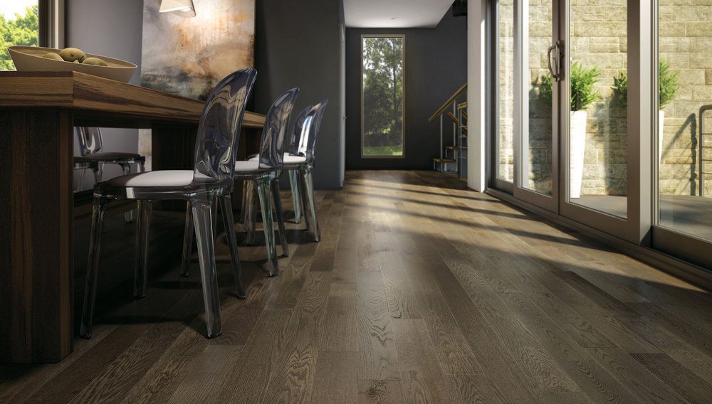 A dining room with hardwood floors and a table and chairs.