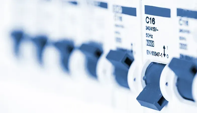 A row of blue and white circuit breakers are lined up in a row.
