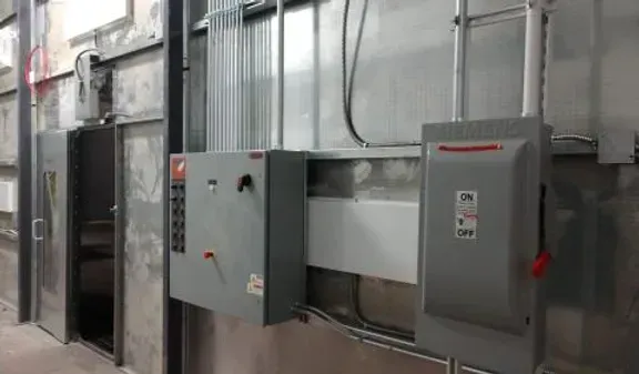 There are a lot of electrical boxes on the wall of a building.