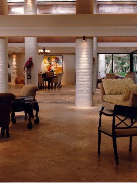 Spacious lobby with stone columns, warm lighting, and seating near large windows.