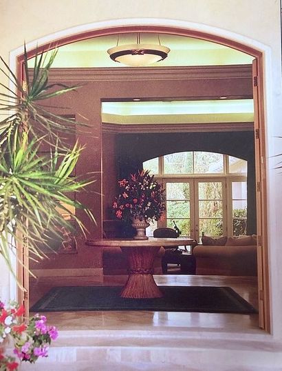 Dark wooden staircase with black wrought-iron railing beside a window and white wall
