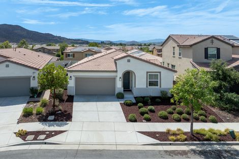 Suburban house with two-car garage, desert landscaping, and mountains in the background