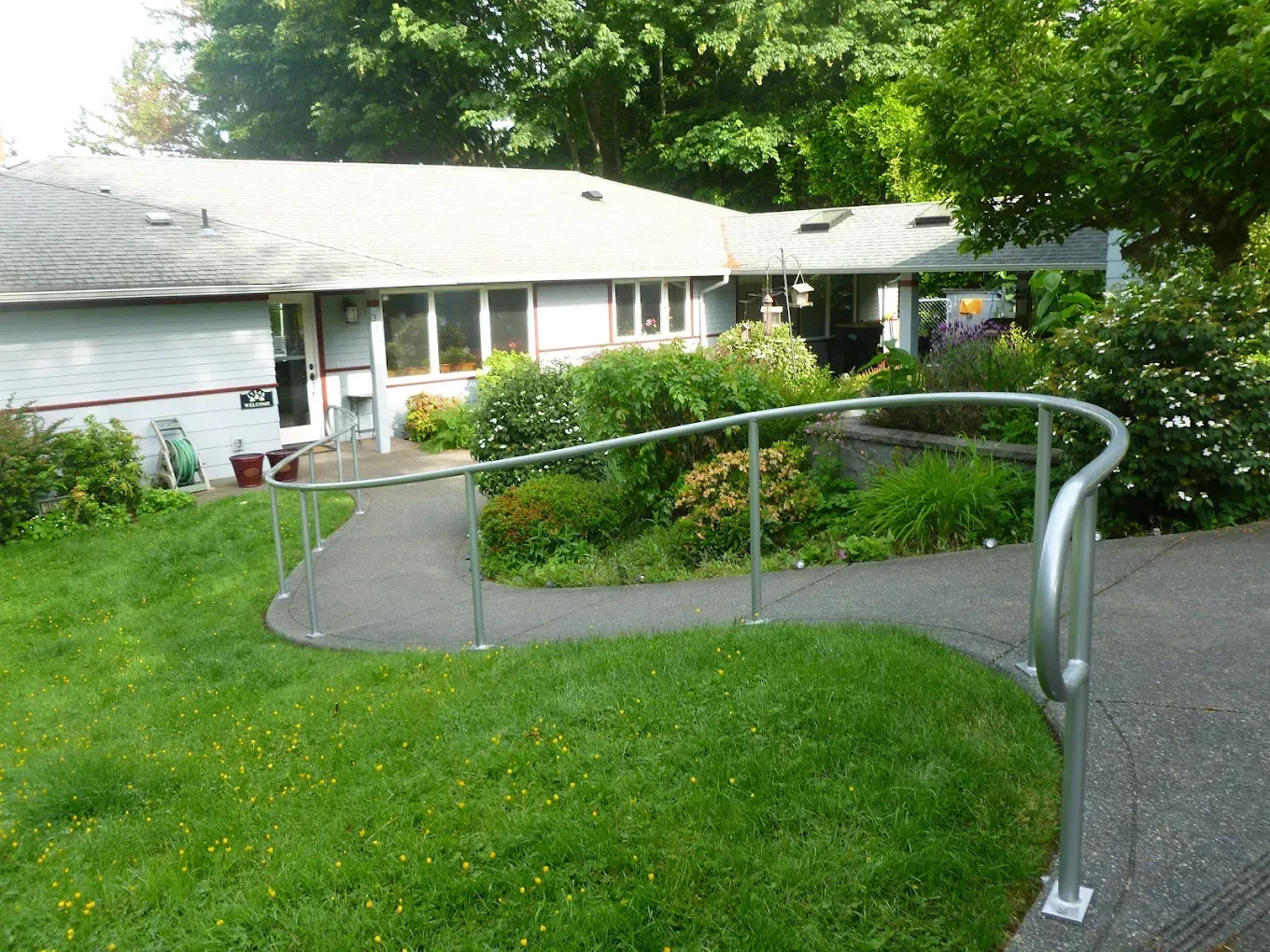 Curved concrete walkway with custom welded steel ADA handrail system