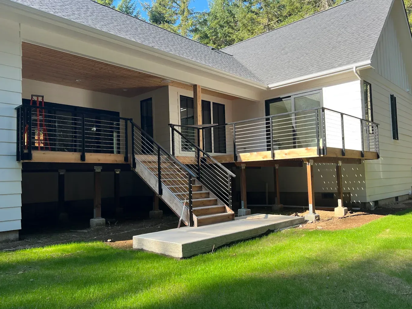 Residential deck with custom welded steel horizontal railing system and stairs