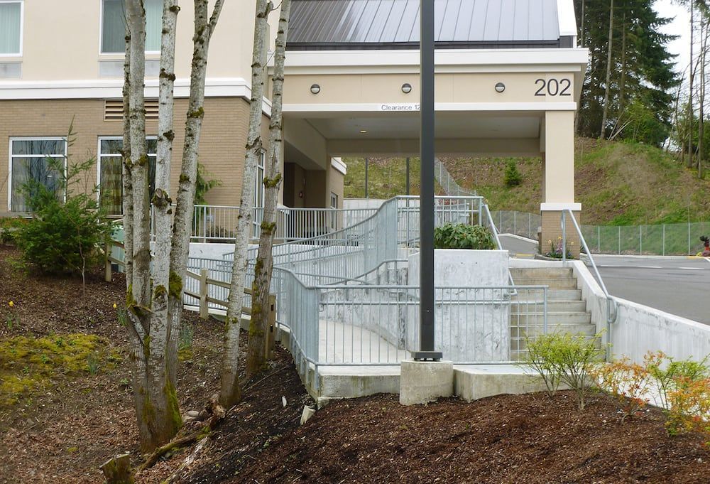 Commercial ADA ramp with custom welded steel railing system and curved sections