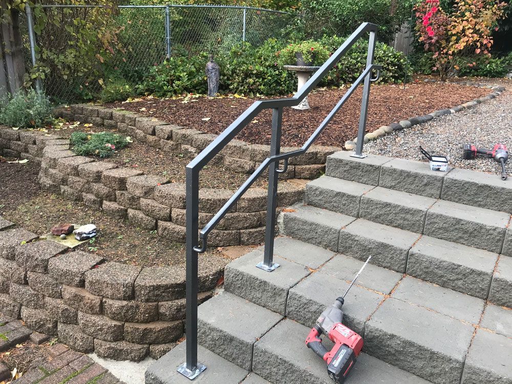 Outdoor concrete steps with custom welded steel handrail installation