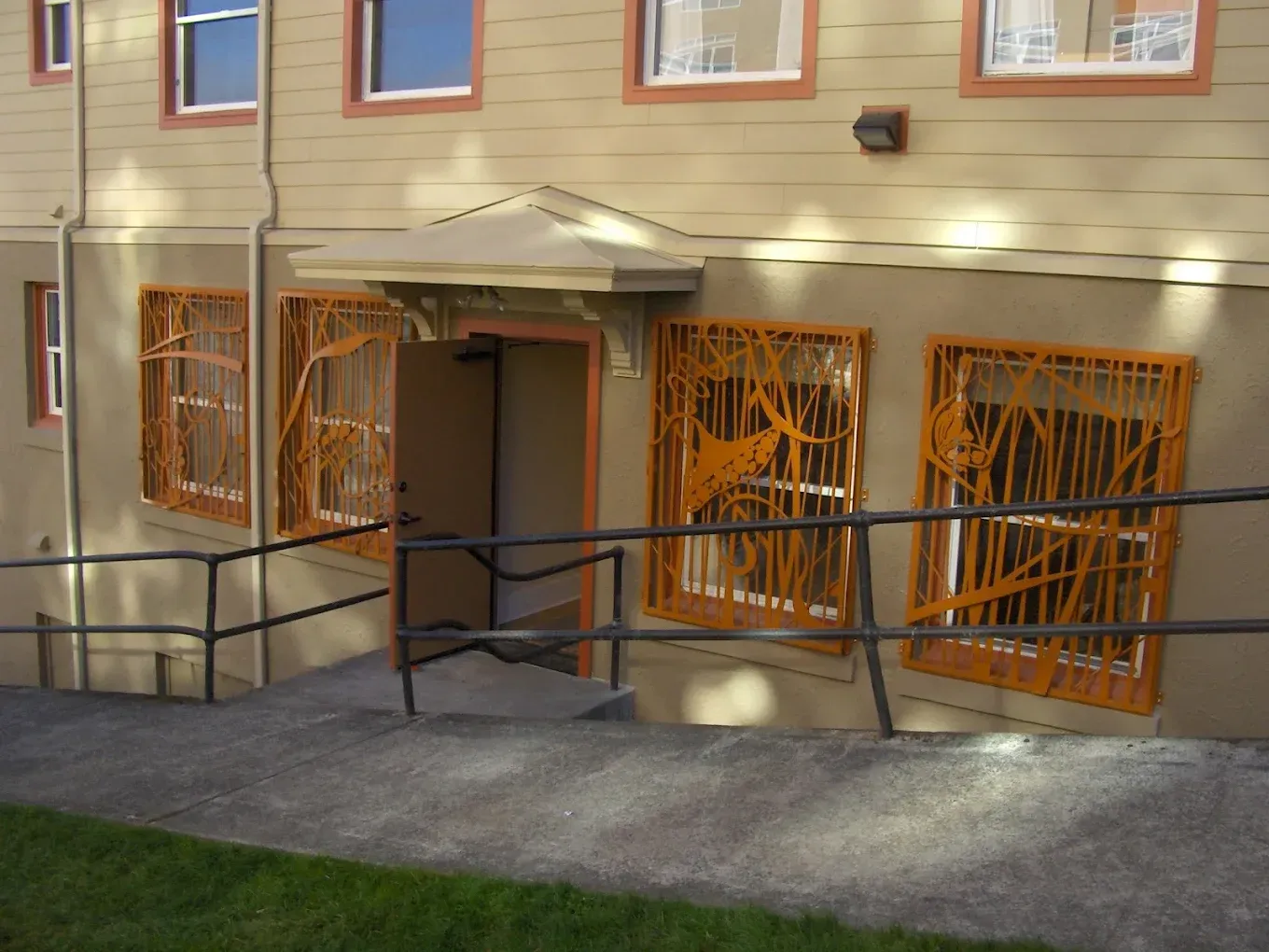 Residential building with custom welded steel railing system and security panels
